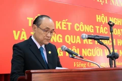 Ông Trần Văn Thọ, Chủ tịch Hội người Việt Nam tại tỉnh Khammoun, Trung Lào đọc báo cáo tại Hội nghị. (Ảnh: Phạm Kiên/TTXVN)