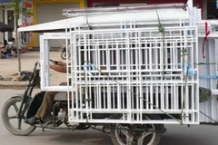 Có khá nhiều xe ba bánh vẫn chở hàng cồng kềnh lưu thông trên đường. (Ảnh: Mạnh Hùng/Vietnam+)