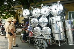 Lực lượng Cảnh sát giao thông tiến hành kiểm tra đối với xe ba bánh tự chế chở hàng cồng kềnh trên đường Trần Nhật Duật. (Ảnh: Việt Hùng/Vietnam+)