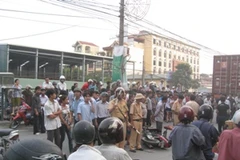 Lực lượng chức năng có mặt hiện trường để giải tỏa giao thông. (Ảnh: Mạnh Hùng/Vietnam+).