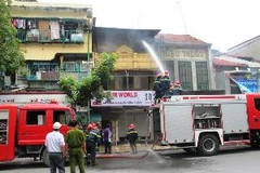 Cảnh sát phòng cháy chữa cháy đang tiến hành dập tắt vụ cháy. (Ảnh: Mạnh Hùng/Vietnam+)