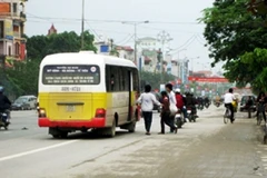 Những chiếc xe kiểu dáng "nhái" giống hệt xe buýt vẫn ngang nhiên bắt khách dọc đường. (Ảnh: Mạnh Hùng/Vietnam+).