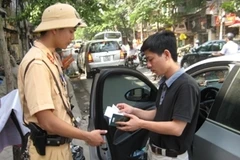 Lực lượng Cảnh sát giao thông đang tiến hành xử lý xe để sai quy định. (Ảnh: Mạnh Hùng/Vietnam+)