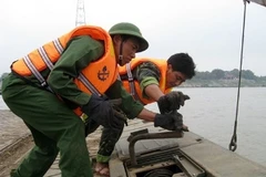 Các chiến sĩ công binh đang làm nhiệm vụ tháo dỡ cầu phao Chèm. (Ảnh: Mạnh Hùng/Vietnam+)