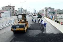 Thi công trải lớp bê tông nhựa ở đường vành đai 3 trên cao. (Ảnh: Huy Hùng/TTXVN)