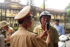 Cảnh sát giao thông đang yêu cầu người điều khiển phương tiện kiểm tra nồng độ cồn. (Ảnh: Việt Hùng/Vietnam+)