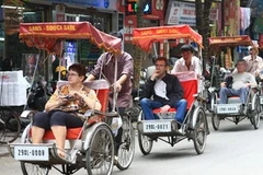 Du khách Pháp thăm phố cổ Hà Nội bằng xích lô. (Ảnh: Anh Tuấn/TTXVN)