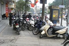Nhiều điểm trông giữ xe vẫn để phương tiện tràn lan dưới vỉa hè. (Ảnh: Diệu Linh/Vietnam+)