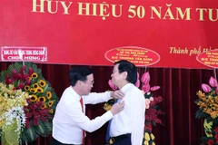 Ủy viên Bộ Chính trị, Thường trực Ban Bí thư Võ Văn Thưởng (trái) trao tặng Huy hiệu 50 năm tuổi Đảng cho nguyên Chủ tịch nước Trương Tấn Sang. (Ảnh: Xuân Khu/TTXVN)