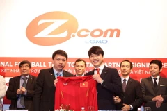 Tổng thư ký VFF Lê Hoài Anh tặng áo thi đấu của đội tuyển cho đại diện tập đoàn GMO Z.com. (Ảnh: Quốc Khánh/TTXVN)