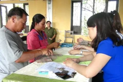 Người dân xã Lộc Điền nhận tiền bồi thường. (Ảnh: Tường Vi/TTXVN)