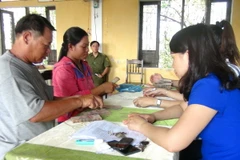 Người dân xã Lộc Điền nhận tiền bồi thường. (Ảnh: Tường Vi/TTXVN)