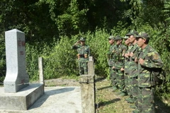 Các chiến sỹ Bộ đội biên phòng Đồn Biên phòng Pa Thơm kiểm tra cột mốc 110, phân định ranh giới chủ quyền với nước bạn Lào. (Ảnh: Xuân Tiến/TTXVN)