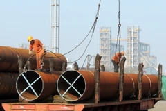 Công nhân vận chuyển thép tại một cảng ở thành phố Liên vận cảng, tỉnh Giang Tô, Trung Quốc. (Nguồn: AFP/TTXVN)