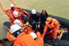 Lực lượng Trung tâm phối hợp tìm kiếm cứu nạn hàng hải Việt Nam đưa thi thể thuyền viên được tìm thấy mặc kẹt trong tàu VTB 26 lên tàu để đưa vào đất liền. (Ảnh: Tá Chuyên/TTXVN)