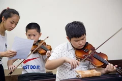 Các nghệ sỹ nhí đang tập luyện chuẩn bị cho buổi diễn. (Ảnh: PV/Vietnam+)