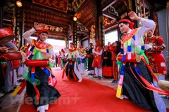Những chàng trai đóng giả con gái trong hội làng Triều Khúc (Hà Nội). (Ảnh: Vietnam+)