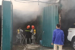 Hiện cảnh sát đang nỗ lực phá lớp tôn bên ngoài hông của dãy xưởng để tiếp cận sâu hơn vào khu vực bên trong. (Ảnh: Sơn Bách/ Vietnam+)