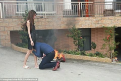 Anh chồng quỳ xuống ôm chân vợ trong một bức ảnh đang gây xôn xao dư luận Trung Quốc (Nguồn: Daily Mail)