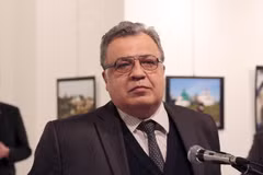 Trong một bức ảnh của Burhan Ozbilici, tay súng đứng ngay sau Đại sứ Nga Andrei Karlov. (Nguồn: AP) 