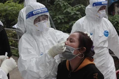 Ngành y tế lấy mẫu sàng lọc xét nghiệm COVID-19 cho người dân khu vực bị phong tỏa. (Ảnh: Đức Phương/TTXVN)