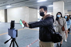 Người dân di chuyển bằng phương tiện tàu điện trên cao sẽ phải dùng CCCD gắn chíp điện tử hoặc dùng ứng dụng PC-COVID để quét mã QR tại các ga đường sắt trên cao. (Ảnh: Phạm Kiên/TTXVN)