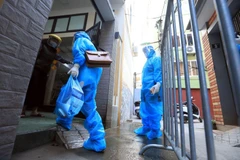 Nhân viên y tế xã Tam Hiệp, huyện Thanh Trì đến kiểm tra sức khỏe và phát thuốc cho trường hợp F0 đang điều trị tại nhà. (Ảnh: Tuấn Anh/TTXVN)