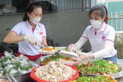 Nhóm Thiện Tâm chuẩn bị các phần cơm cho người có hoàn cảnh khó khăn. (Ảnh: Tường Vi/TTXVN)