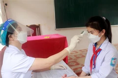 Khám sàng lọc trước khi tiêm vaccine phòng COVID-19 cho trẻ 11 đến dưới 12 tuổi tại Trường Trung học cơ sở Yên Định, huyện Hải Hậu, tỉnh Nam Định. (Ảnh: Văn Đạt/TTXVN)