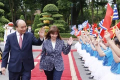 Chủ tịch nước Nguyễn Xuân Phúc và Tổng thống Hy Lạp Katerina Sakellaropoulou với thiếu nhi Hà Nội tại lễ đón. (Ảnh: Thống Nhất/TTXVN)