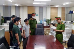 Lực lượng chức năng đọc lệnh bắt các bị can liên quan đến vụ án xảy ra tại Bệnh viện Đa khoa Đồng Nai, Công ty AIC và các đơn vị liên quan. (Ảnh: Phạm Kiên/TTXVN)