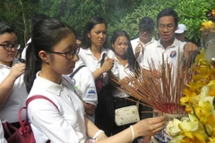 Đoàn thanh niên, sinh viên kiều bào dâng hương trước mộ cụ Huỳnh Thúc Kháng. (Ảnh: Phước Ngọc/TTXVN)