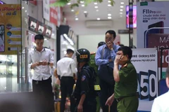 Cảnh sát kiểm tra, khám xét tại cửa hàng điện thoại Nhật Cường mobile ở 33 Lý Quốc Sư, Hà Nội. (Ảnh: Doãn Tấn/TTXVN)