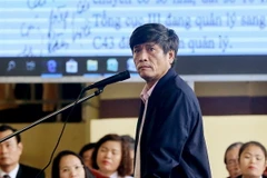 Bị cáo Nguyễn Thanh Hóa xem các văn bản là tang vật của vụ án được chiếu trên màn hình. (Ảnh: Trung Kiên/TTXVN)