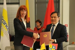 Thứ trưởng Bộ Kế hoạch và Đầu tư Vũ Đại Thắng và Tổng Giám đốc Cơ quan ngoại giao Wallonie-Bruxelles, Pascale Delcomminette trao biên bản hợp tác được ký kết. (Ảnh: Kim Chung/ TTXVN)