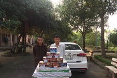 Hai đối tượng và tang vật trong đường dây buôn bán pháo lậu bị bắt giữ. (Ảnh: TTXVN phát)