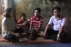 Anh Binh (giữa) với chân phải đã bị cắt cụt. (Ảnh: Hồng Điệp/TTXVN)