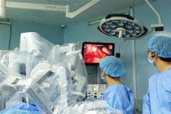 Các bác sỹ Bệnh viện Bình Dân dùng robot phẫu thuật cứu thai phụ khỏi nguy cơ sốc nhiễm trùng đường mật do sỏi ống mật chủ diễn tiến viêm tụy cấp. (Ảnh: TTXVN phát)