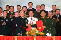 Đại tướng Ngô Xuân Lịch và Thượng tướng Ngụy Phượng Hòa ký Biên bản giao lưu. (Ảnh: Dương Giang/TTXVN)