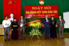 Đồng chí Trần Quốc Vượng tặng hoa chúc mừng cán bộ và nhân dân xã Kim Bình. (Ảnh: Quang Cường/TTXVN)