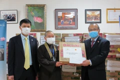 Đại sứ Việt Nam tại Nhật Bản Vũ Hồng Nam (bên phải) và ông Kiều Anh, Giám đốc Văn phòng Đại diện Vietnam Airlines tại Nhật Bản (bên trái) trao mỳ cho sư cô Thích Tâm Trí, Chủ tịch Hội Phật tử Việt Nam tại Nhật Bản. (Ảnh: Đào Thanh Tùng/TTXVN)