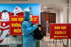 Phóng viên TTXVN tác nghiệp trong khu cách ly của Viện Huyết học Truyền máu Trung ương. (Ảnh: TTXVN)