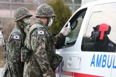 Binh sỹ Hàn Quốc kiểm tra thân nhiệt lái xe cứu thương đề phòng dịch COVID-19 tại căn cứ ở Bắc Daegu, cách Seoul khoảng 300km về phía Đông Nam ngày 26/2/2020. (Ảnh: YONHAP/TTXVN)