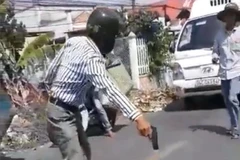 Ông Huỳnh Văn Đài cầm vật nghi là súng đe dọa người va chạm giao thông với ông. (Ảnh: TTXVN phát)