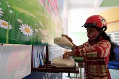 Người dân nhận gạo từ 'ATM gạo' tại thị trấn Khánh Vĩnh (huyện Khánh Vĩnh, Khánh Hoà) trong ngày 25/4. (Ảnh: Nguyễn Dũng/TTXVN)