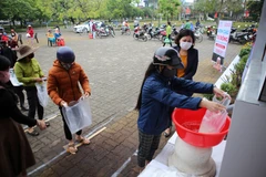 Người dân nhận gạo tại cây ATM gạo tự động. (Ảnh: Hồ Cầu/TTXVN)