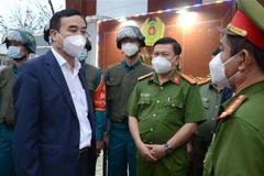 Chủ tịch UBND thành phố Đà Nẵng Lê Trung Chinh (bên trái) thăm hỏi, động viên lực lượng 8394 phường Xuân Hà (quận Thanh Khê, thành phố Đà Nẵng). (Ảnh: Quốc Dũng/TTXVN)