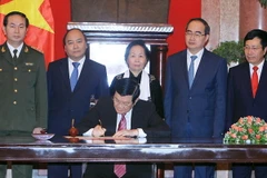 Chủ tịch nước Trương Tấn Sang ký‎ Lệnh công bố Hiến pháp nước CHXHCN Việt Nam ngày 8/12/2013. (Ảnh: Nguyễn Khang/TTXVN)