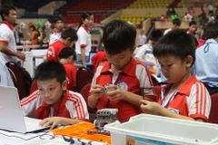 Các thí sinh lắp ráp và lập trình trên máy tính trong cuộc thi Robothon 2014. (Nguồn: TTXVN)