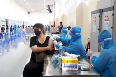 Tiêm vaccine cho công nhân đang làm việc theo phương án 3 tại chỗ. (Ảnh: Thanh Vũ/TTXVN)